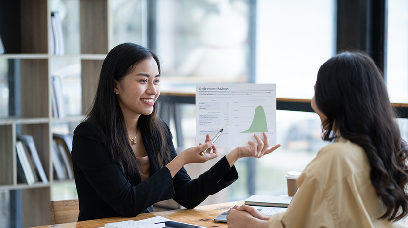 A smiling woman looks at her colleague in a team meeting